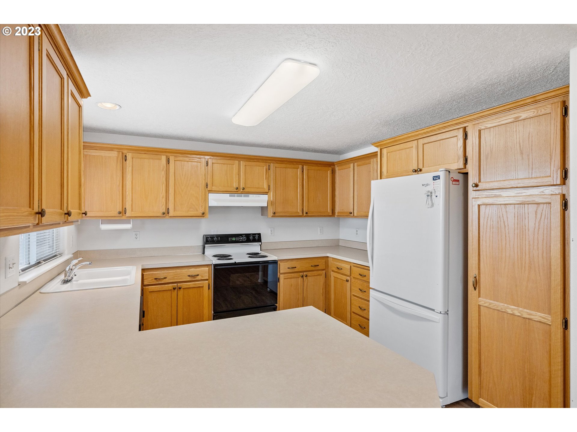 37308 Rachael Drive Sandy, OR 97055 - Photo 10 of 29 a kitchen with stainless steel appliances granite countertop a refrigerator a stove a sink and a microwave