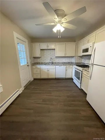 a kitchen with a sink stainless steel appliances and white cabinets