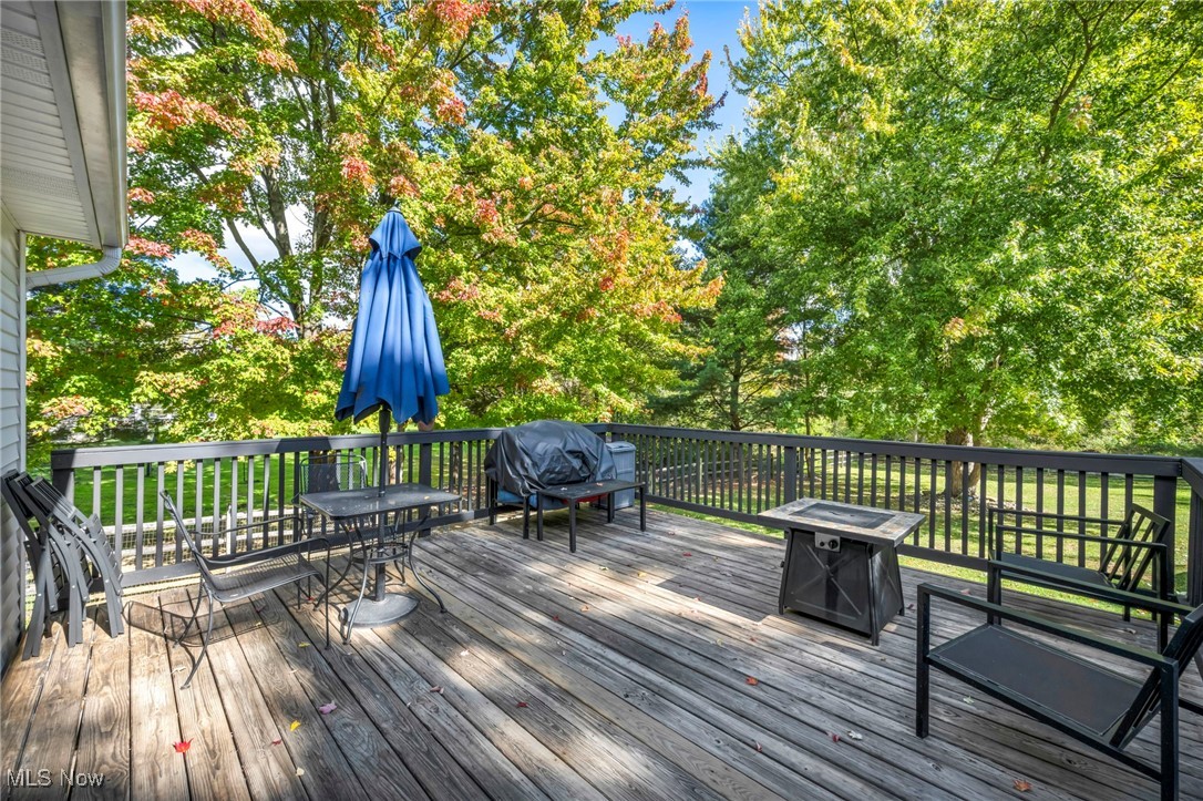 18945 Thorpe Road Chagrin Falls, OH 44023 - Photo 6 of 35 Deck with area for grilling, view of wooded area, an outdoor fire pit, and outdoor dining space