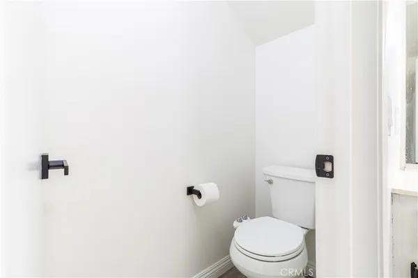 a white toilet sitting next to a white wall