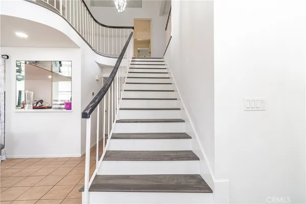 a view of staircase with lots of frames on wall and a rug