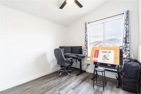 a view of a workspace with furniture and a window