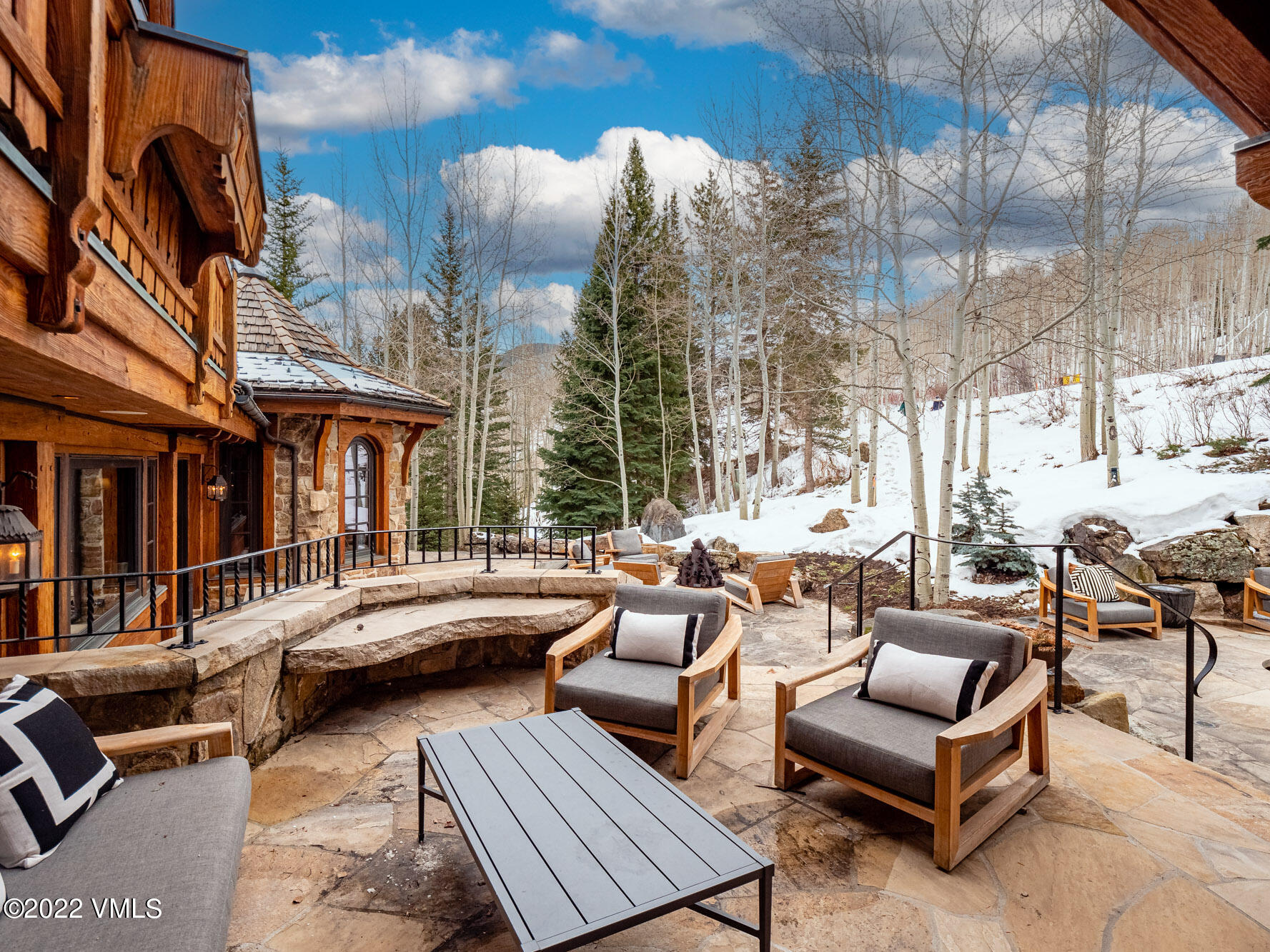 97 Rockledge Road Vail, CO 81657 - Photo 19 of 35 a view of a patio with couches and dining table and chairs with wooden floor
