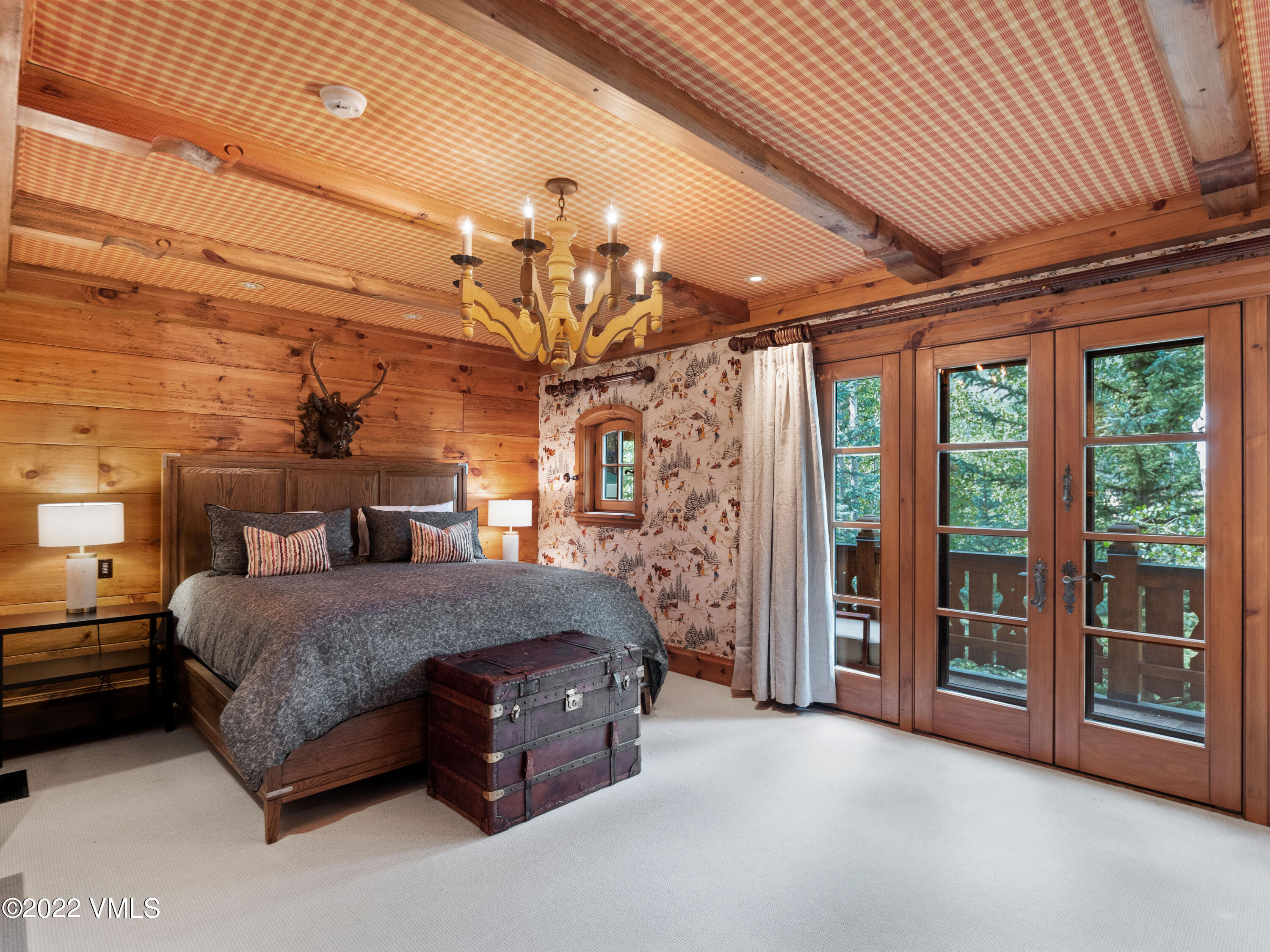 97 Rockledge Road Vail, CO 81657 - Photo 24 of 35 a spacious bedroom with a bed and a chandelier