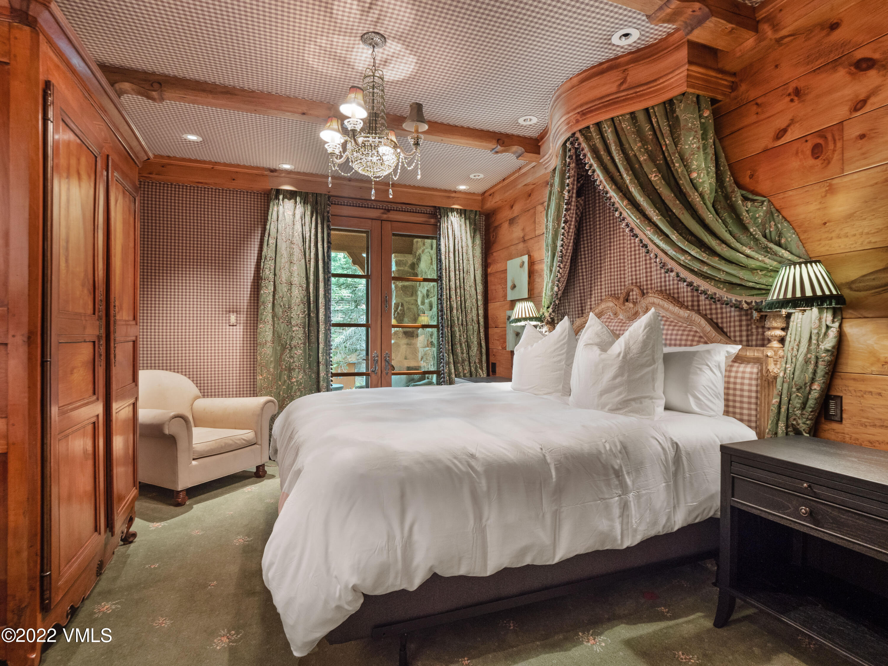 97 Rockledge Road Vail, CO 81657 - Photo 27 of 35 a bedroom with a large bed and a chandelier