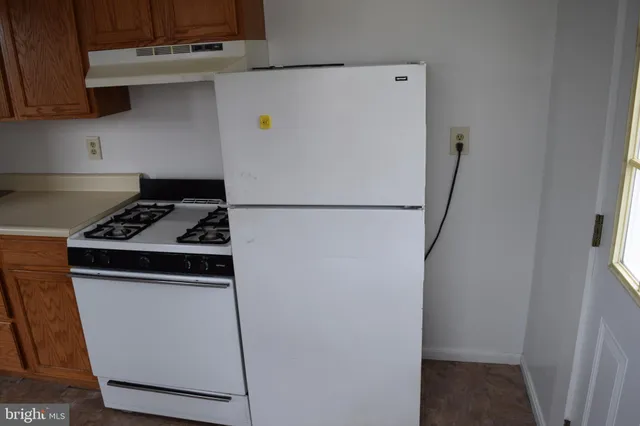 a white refrigerator freezer and a stove sitting inside of a kitchen