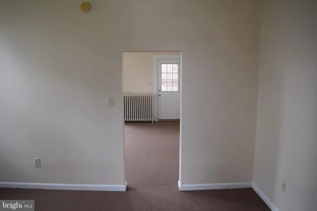 a view of a small space with wooden floor and a window