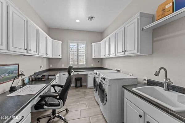 a living room with furniture a rug kitchen view and a chandelier