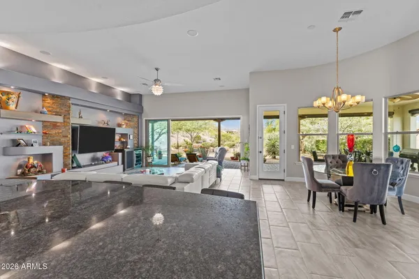 a living room with furniture kitchen view and a chandelier