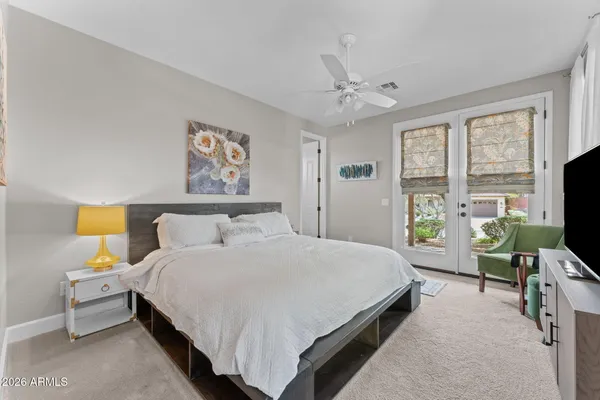 a living room with patio furniture and a potted plant