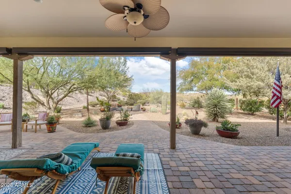 a view of a patio with couches and chairs under an umbrella