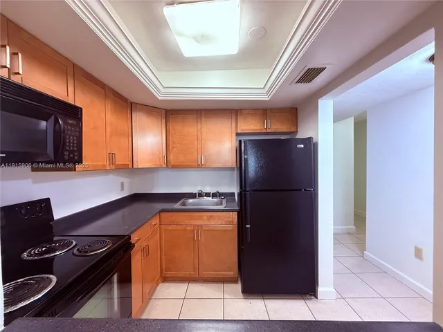 a kitchen with a refrigerator and a stove top oven