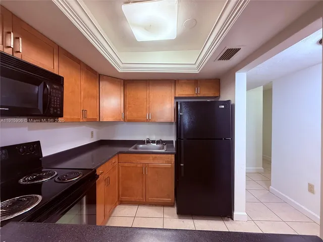 a kitchen with a refrigerator and a stove top oven