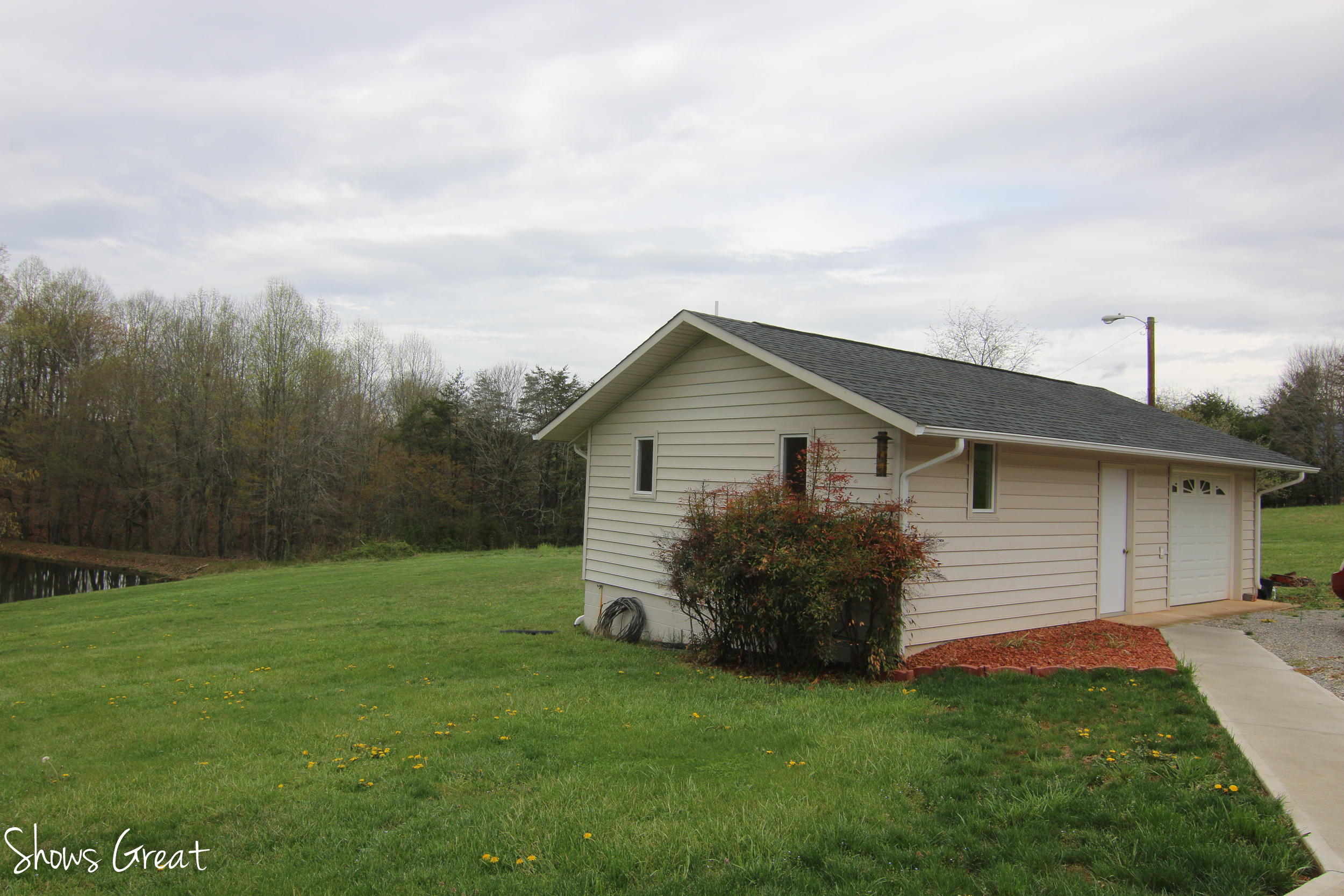 3315 Retreat Road Boones Mill, VA 24065 - Photo 24 of 57 a backyard of a house with potted plants and large tree