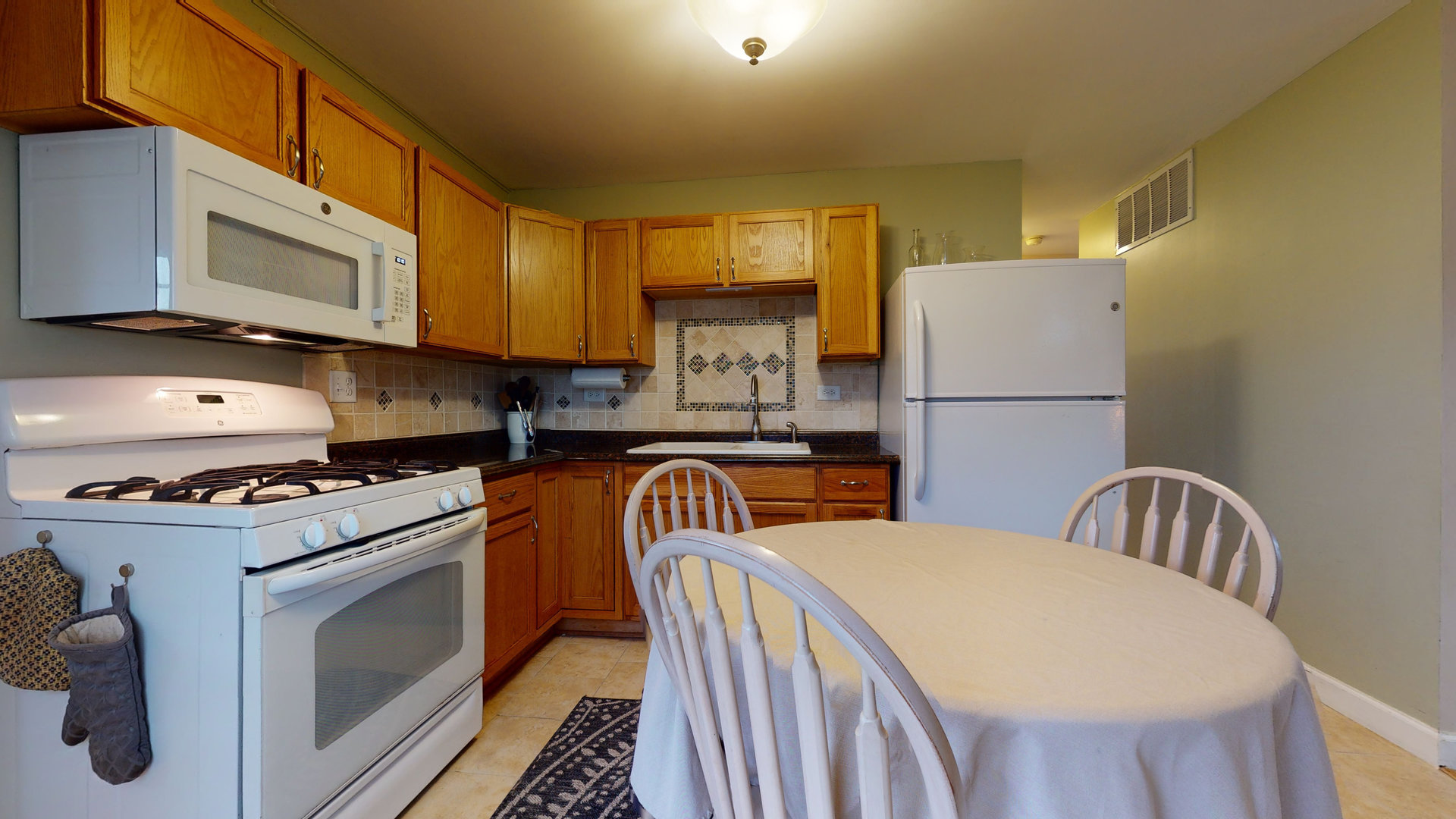 209 Raupp Boulevard Buffalo Grove, IL 60089 - Photo 6 of 13 a kitchen with sink a refrigerator and microwave