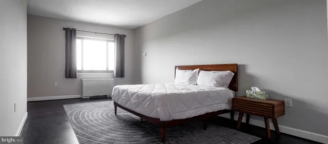 a bedroom with a bed table and a window