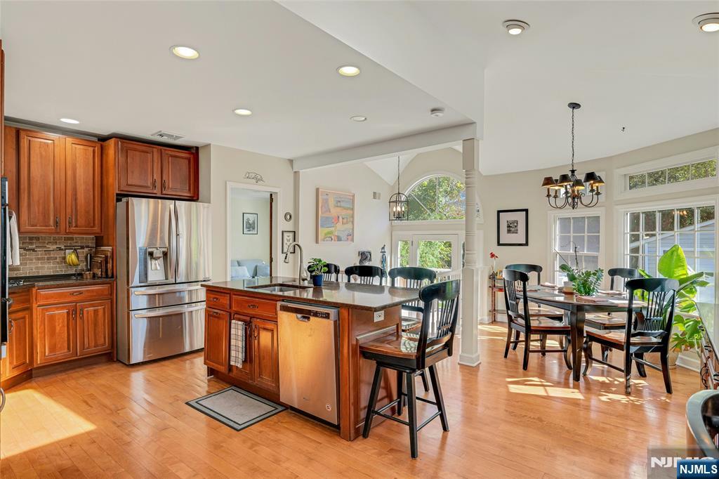 66 Smull Avenue Caldwell, NJ 07006 - Photo 11 of 32 a kitchen with stainless steel appliances granite countertop a refrigerator a stove a sink a dining table and chairs with wooden floor