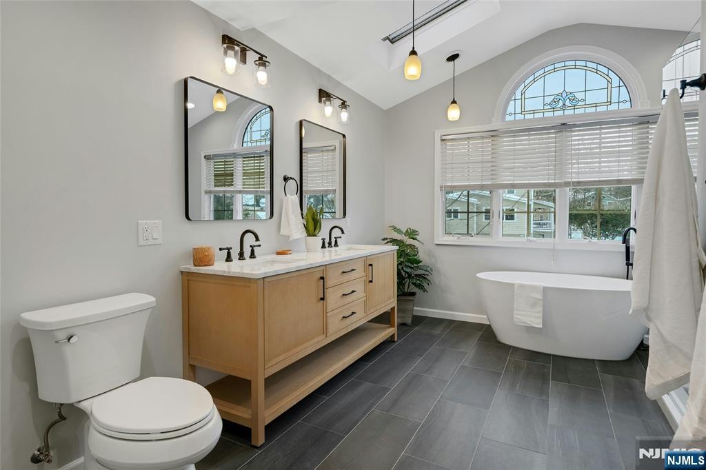66 Smull Avenue Caldwell, NJ 07006 - Photo 20 of 32 a bathroom with a sink a mirror a toilet and a window
