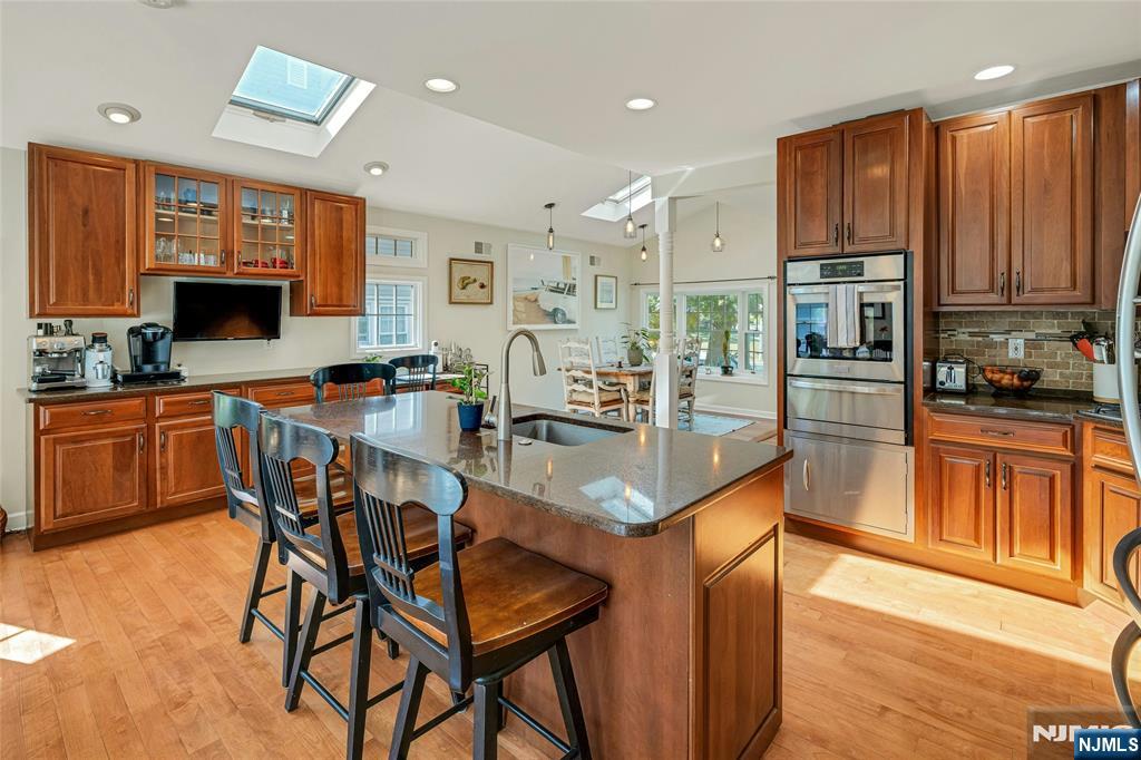66 Smull Avenue Caldwell, NJ 07006 - Photo 10 of 32 a kitchen with stainless steel appliances kitchen island granite countertop a table chairs and a refrigerator