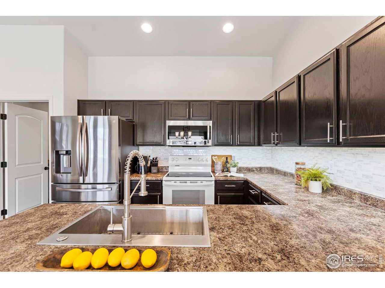 1010 Axis Drive Severance, CO 80550 - Photo 9 of 33 a kitchen with stainless steel appliances granite countertop a refrigerator and a stove