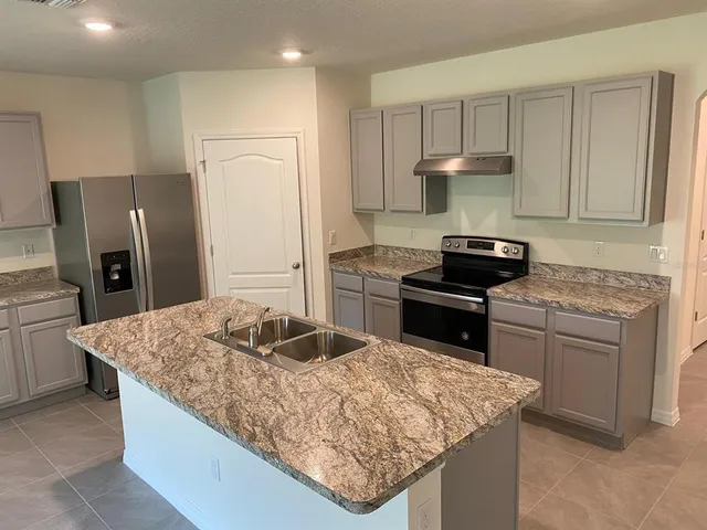 a kitchen with stainless steel appliances granite countertop a sink stove and refrigerator