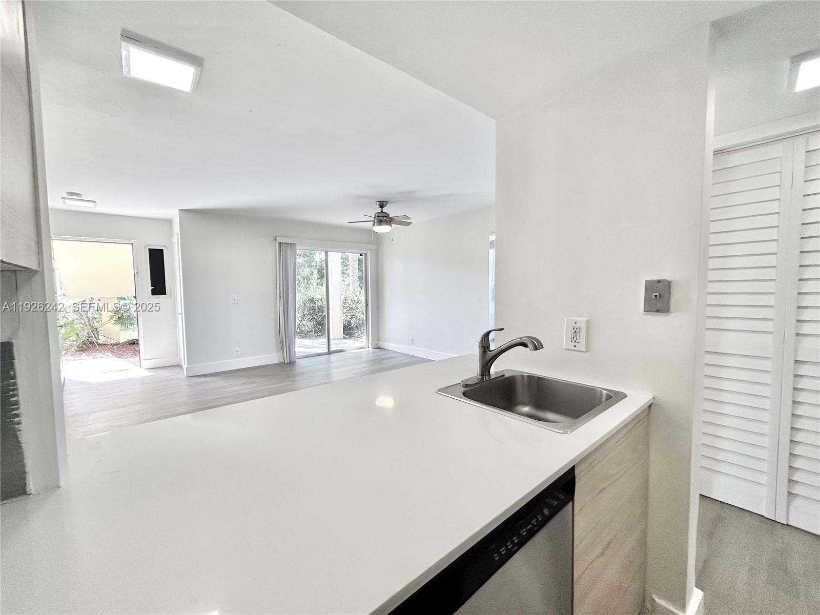 6340 La Costa Drive, Unit A Boca Raton, FL 33433 - Photo 13 of 28 a kitchen with sink cabinets and living room