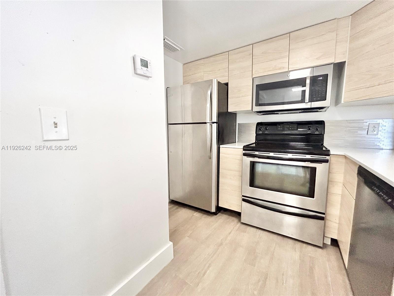 6340 La Costa Drive, Unit A Boca Raton, FL 33433 - Photo 8 of 28 a kitchen with a refrigerator stove and microwave