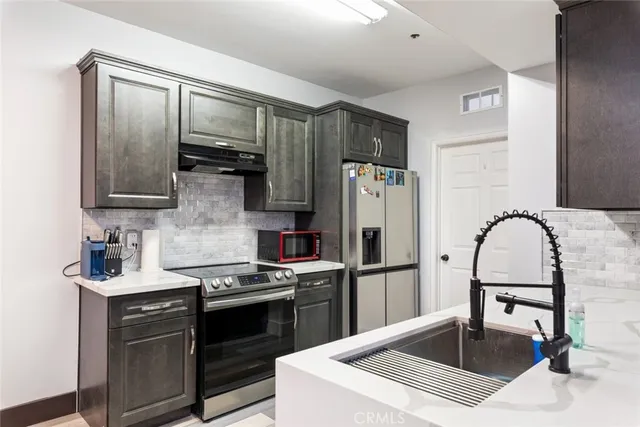 a kitchen with stainless steel appliances a refrigerator sink and cabinets