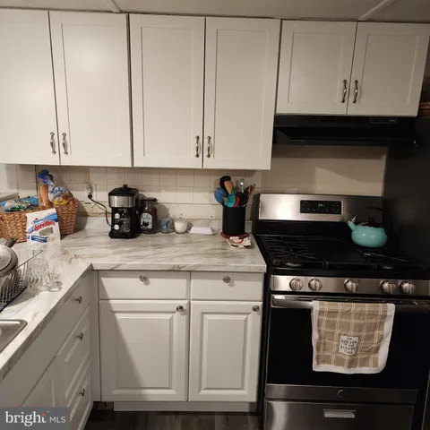 a kitchen with granite countertop white cabinets and black appliances