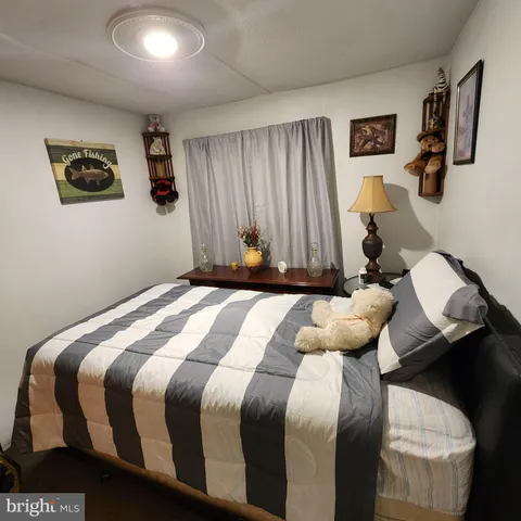 a bedroom with a bed and painting on the wall