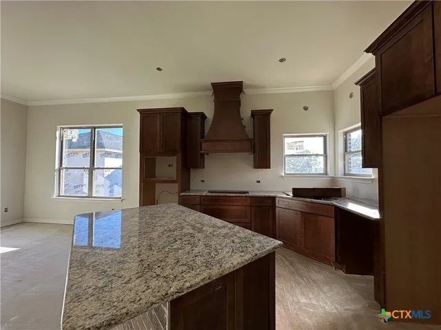 a kitchen with stainless steel appliances granite countertop sink stove and refrigerator