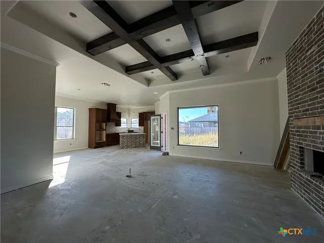 a view of an empty room with a fireplace and a window