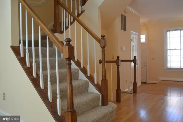 a view of staircase with lots of frames on wall and wooden floor