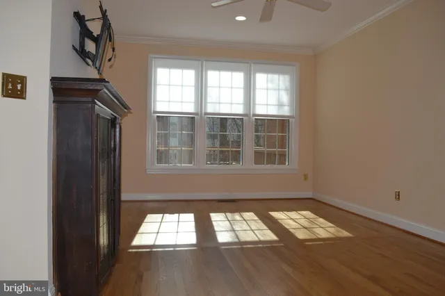 a view of empty room with wooden floor and windows
