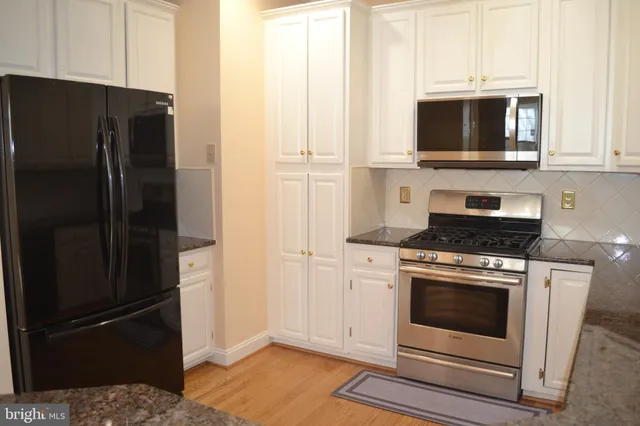a kitchen with stainless steel appliances wooden cabinets and a refrigerator