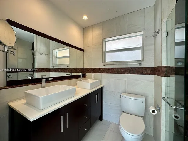 a bathroom with a sink mirror vanity and toilet