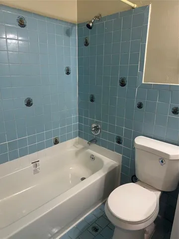 a white toilet and shower in a bathroom