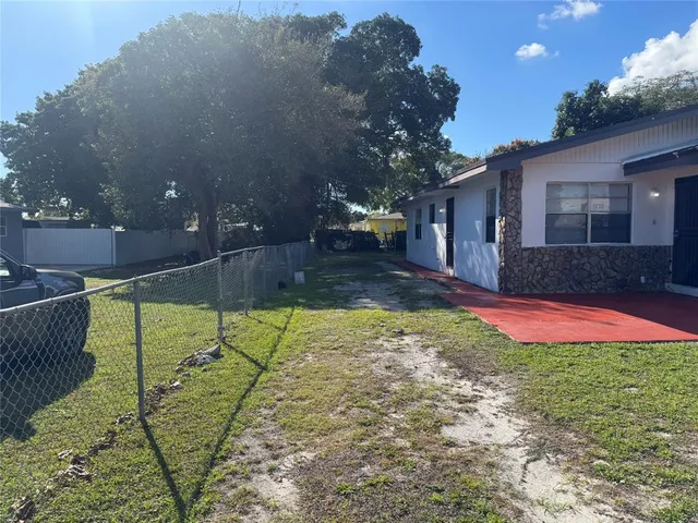 a view of an house with backyard and trees