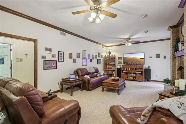 a living room with furniture kitchen view and a flat screen tv