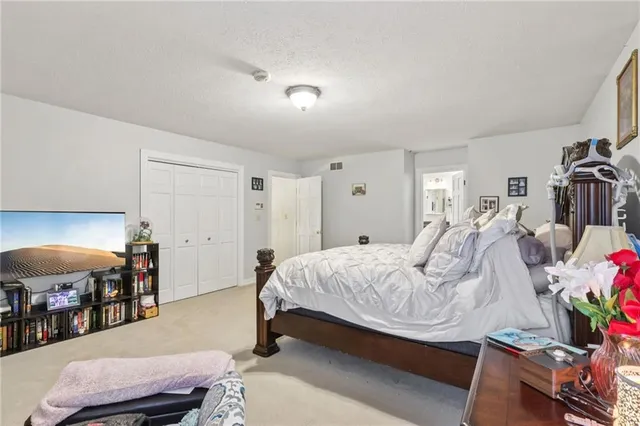 a bedroom with a bed and large windows
