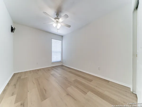 a view of an empty room with a chandelier fan