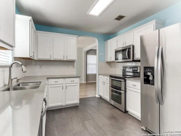 a kitchen with stainless steel appliances granite countertop a refrigerator sink and stove