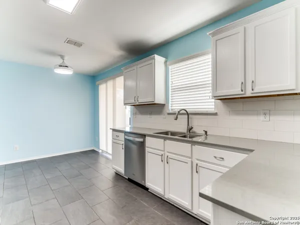 a kitchen with granite countertop a sink stainless steel appliances and cabinets