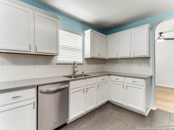 a kitchen with granite countertop white cabinets and white appliances