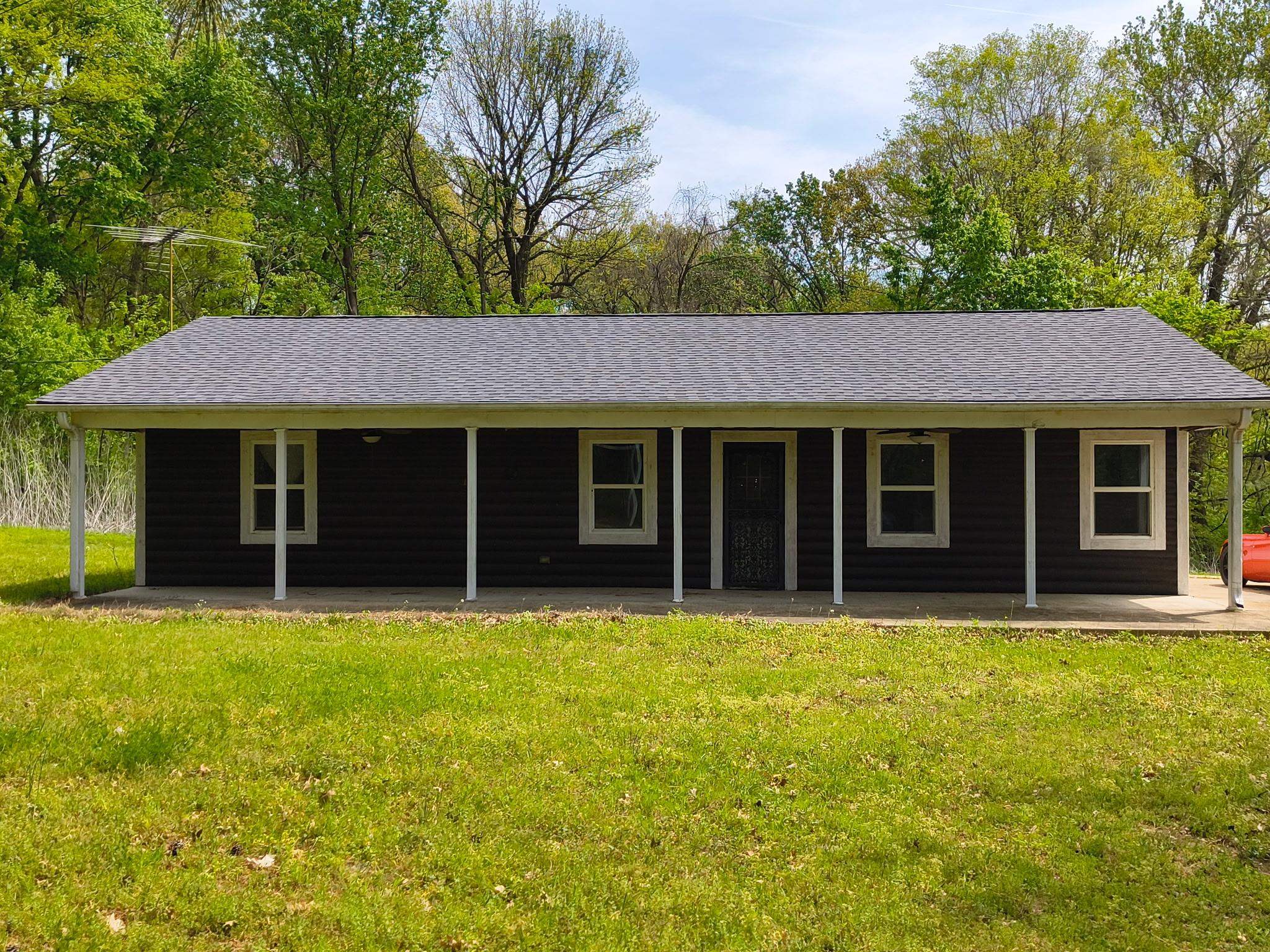 Ranch-style house with a front yard and roof with shingles