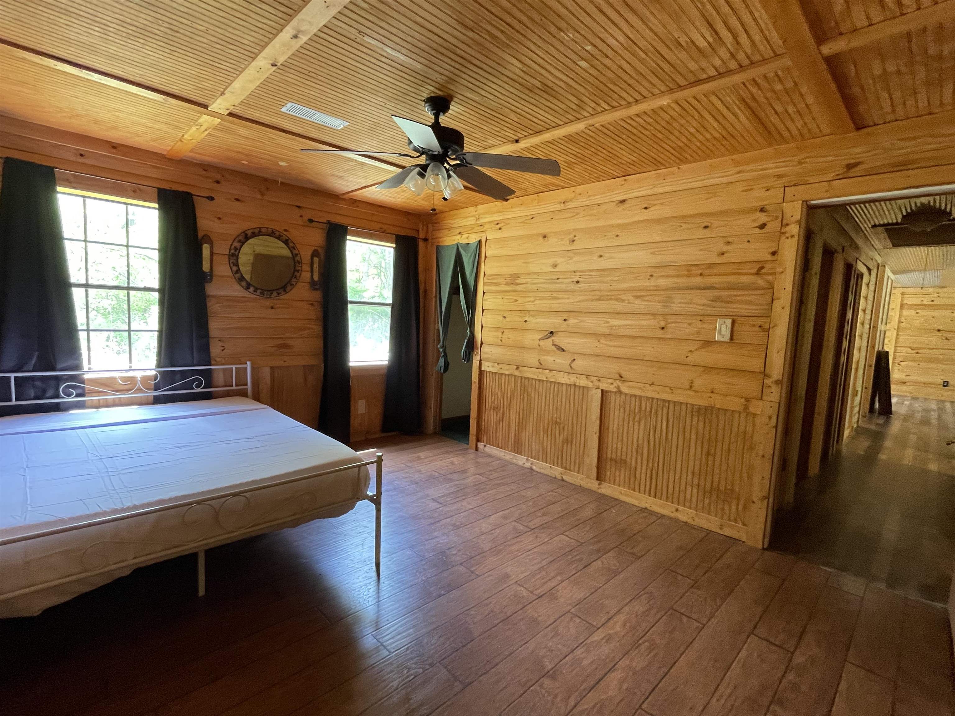 2349 Snyder Bluff Road Ripley, TN 38063 - Photo 11 of 21 Bedroom with wooden walls, wood-type flooring, a ceiling fan, and wooden ceiling
