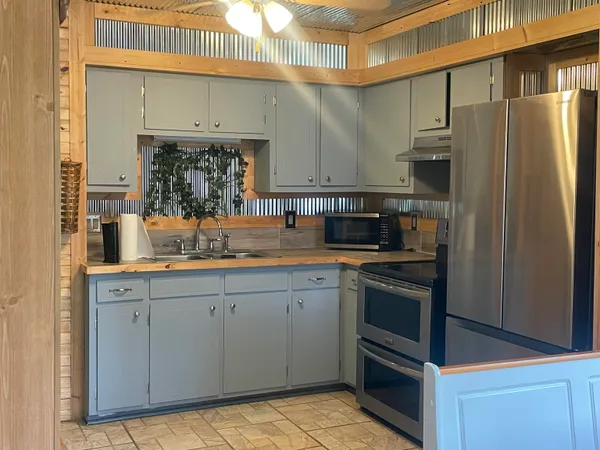 a kitchen with stainless steel appliances a sink stove and refrigerator