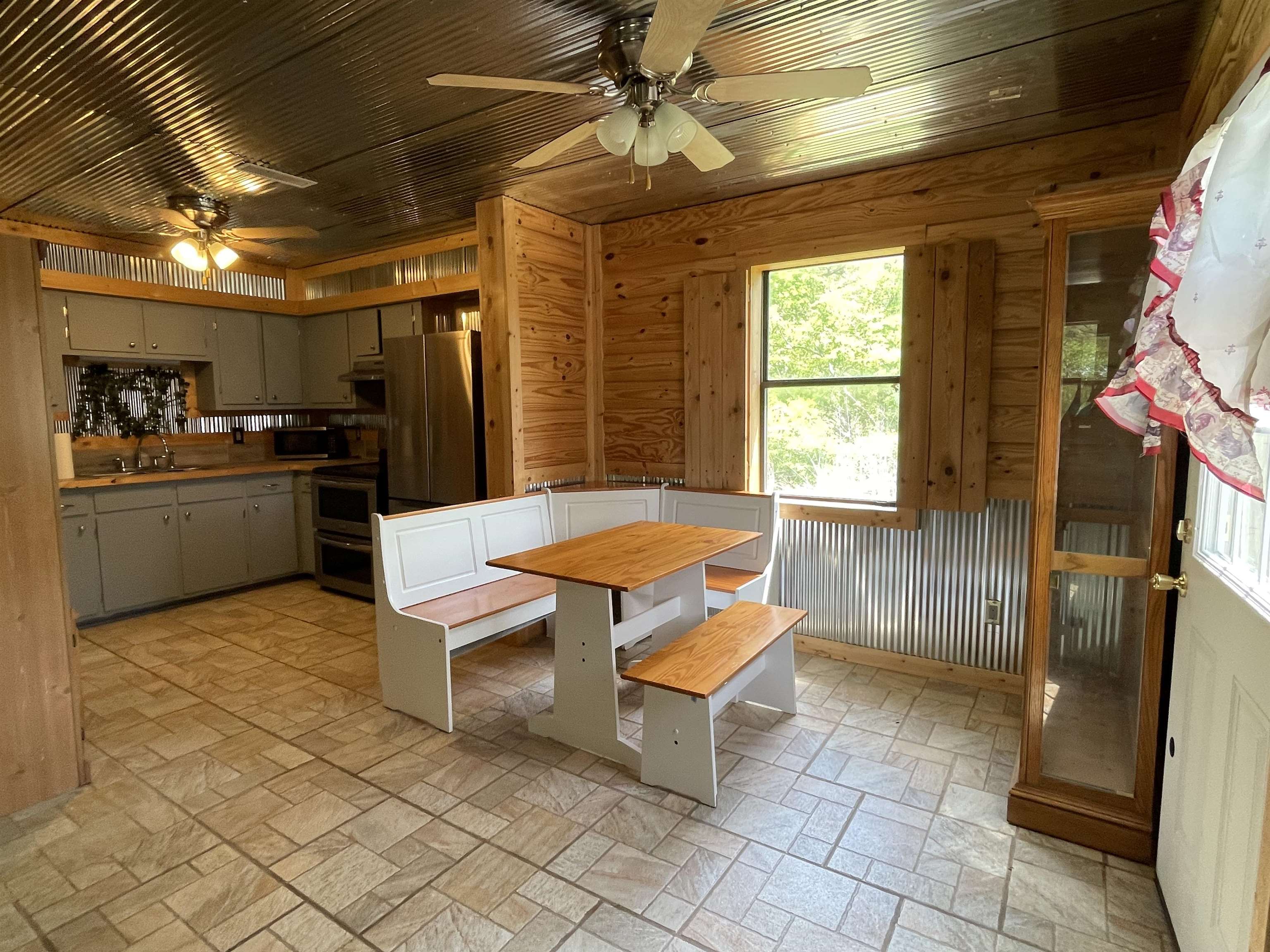 2349 Snyder Bluff Road Ripley, TN 38063 - Photo 9 of 21 Dining area with ceiling fan and wood walls
