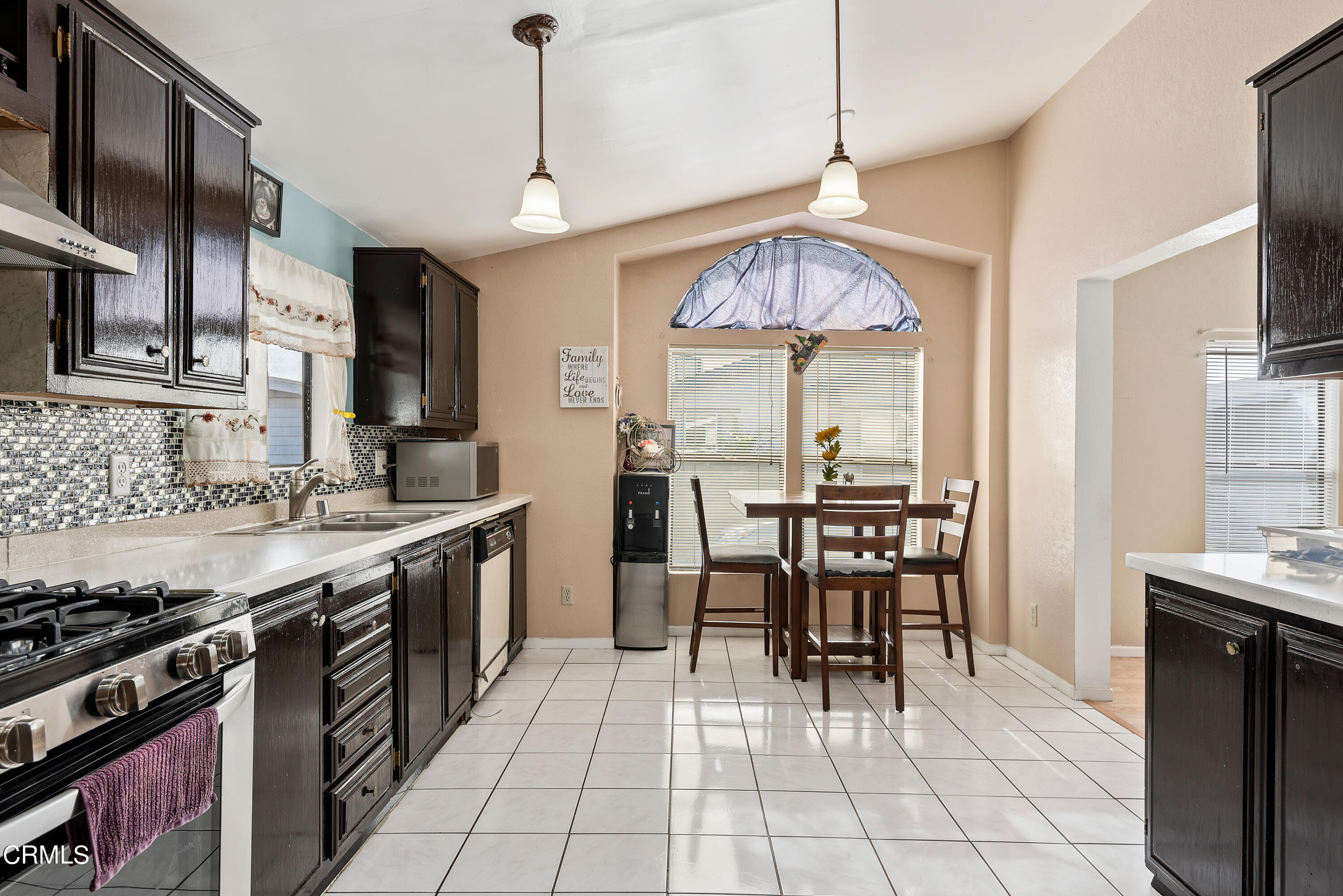 140 Rainbow Drive, Unit 162 Oxnard, CA 93033 - Photo 8 of 19 a kitchen with stainless steel appliances granite countertop a stove a sink dishwasher a dining table and chairs with wooden floor