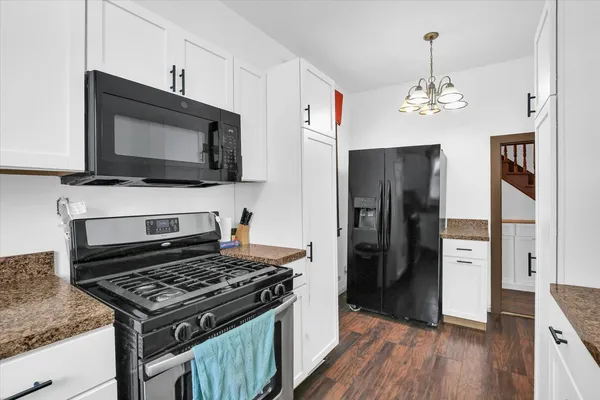 a kitchen with stainless steel appliances wooden floor and a refrigerator